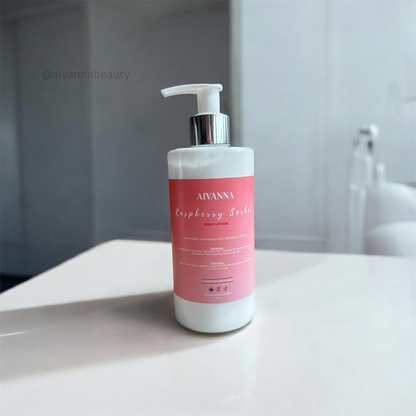 A bottle of Aivanna Raspberry Soft gel moisturizer with a white pump and a pink label, sitting on a white surface with a blurred gray background.