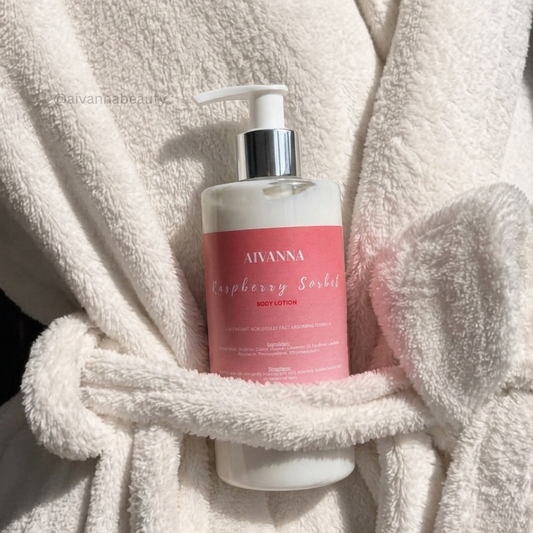 A bottle of Aivanna Raspberry Sorbet body lotion placed against a plush white bathrobe in warm sunlight.